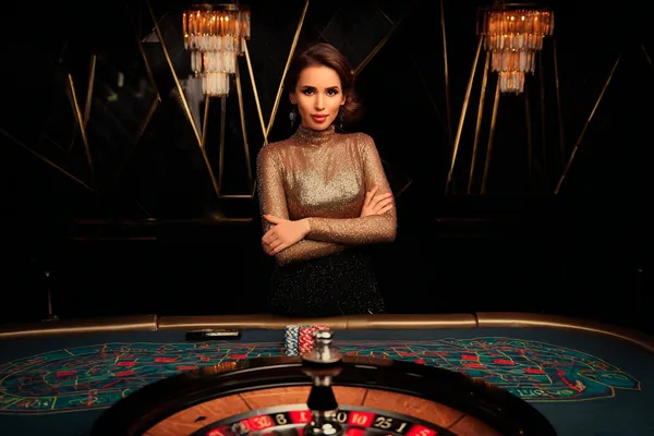 A woman smiling by bright slot machines showing lucky symbols, showcasing the exciting slot offerings at JILIX.